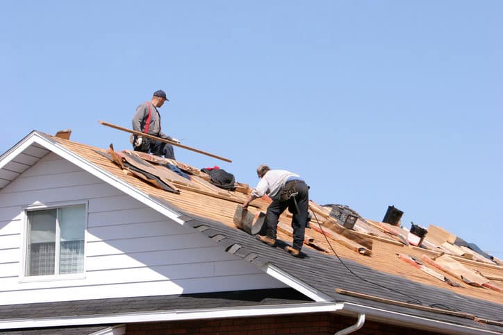 Professional roofer repairing shingles in Fairview residential neighborhood